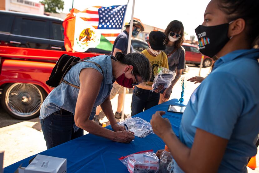 Patricia Connaley, left, fills out raffle information with a Dallas County Census booth...