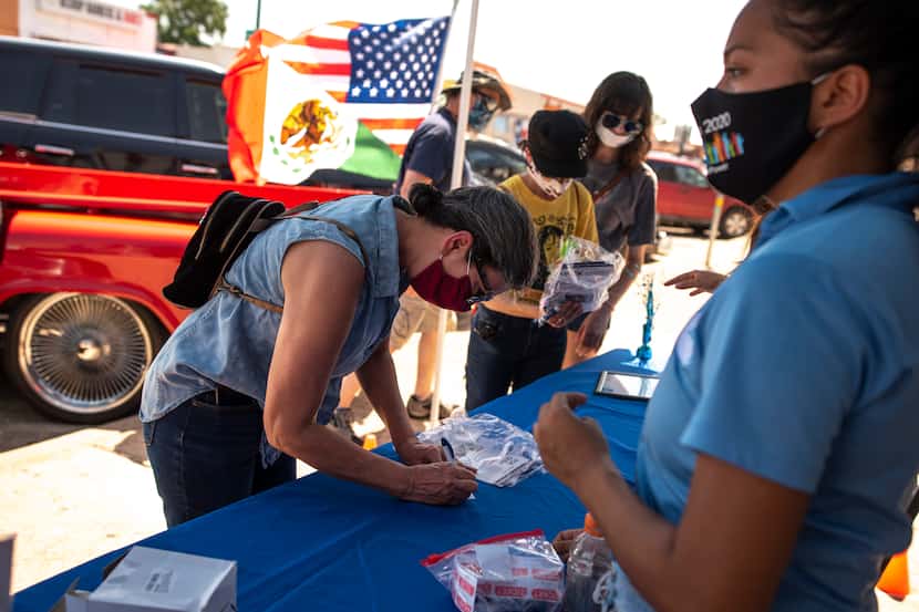 Patricia Connaley, left, fills out raffle information with a Dallas County Census booth...