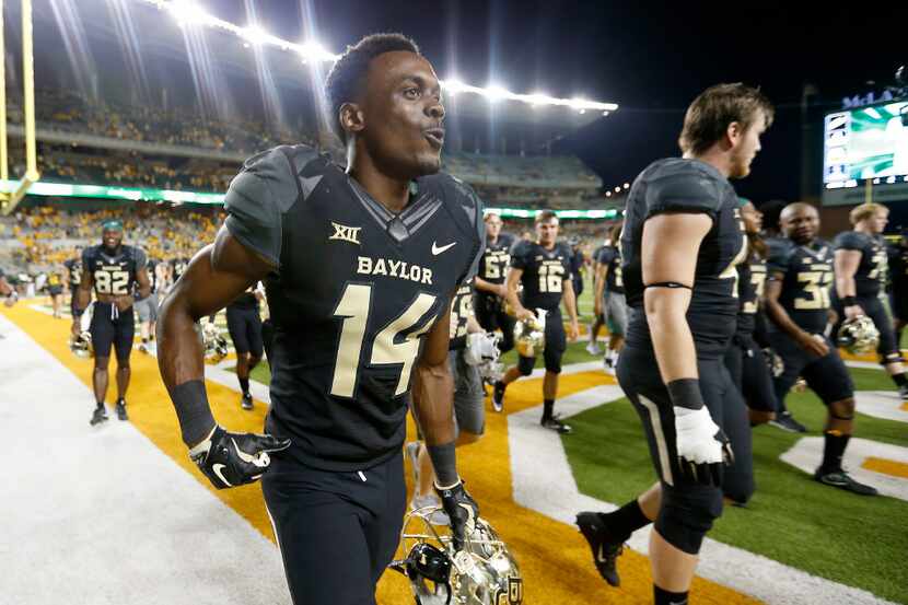 Baylor wide receiver Chris Platt (14) and other players walk off the fields after a 35-24...