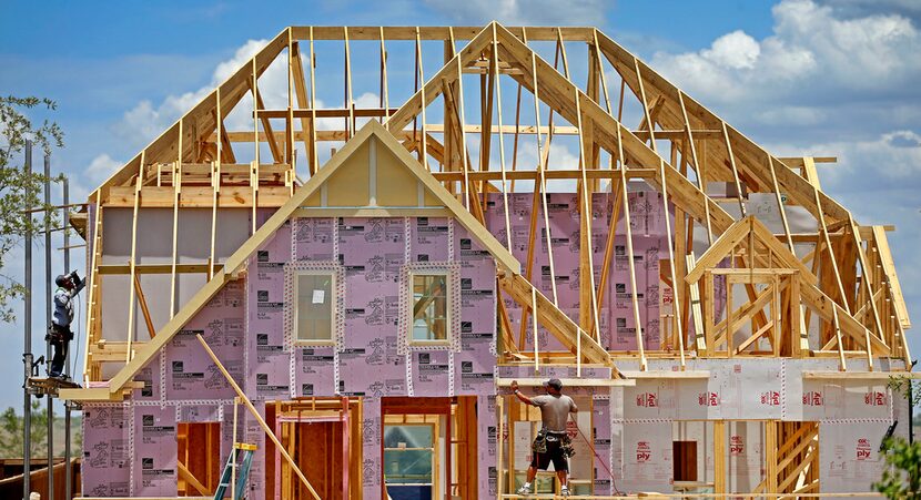 Construction workers frame new homes inside the Walsh development in Fort Worth. 