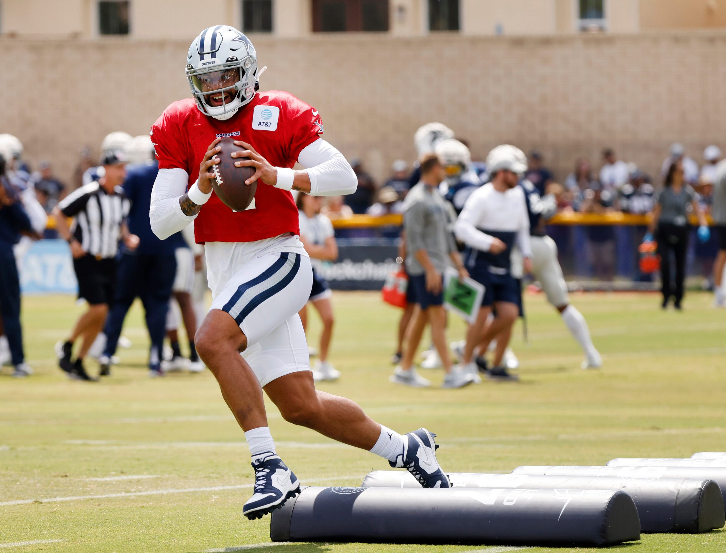 Dallas Cowboys quarterback Dak Prescott (4) traverses the pads as he runs through passing...