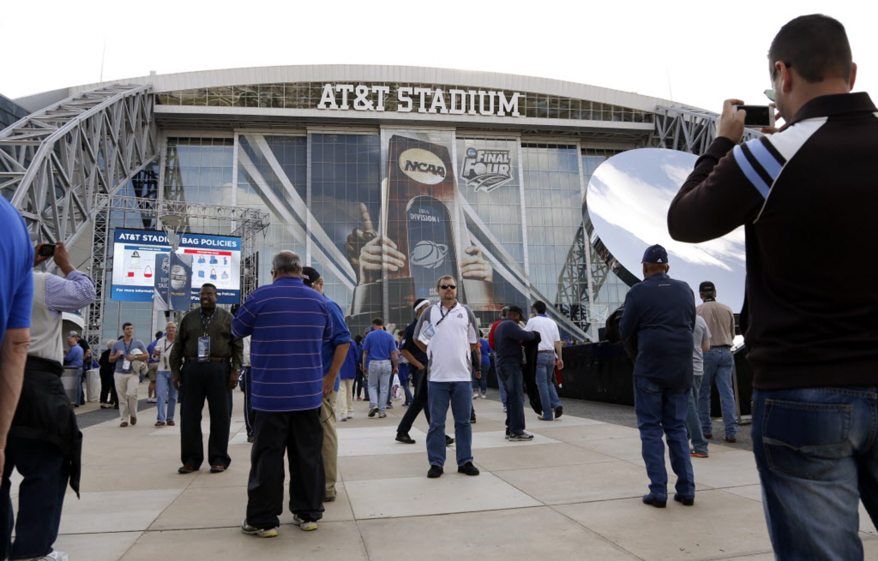 People take photos and walk to AT&T Stadium before the game between the Kentucky Wildcats...