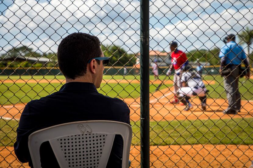 Texas Rangers general manager Jon Daniels watches Cuban outfield Julio Pablo Martinez hit...