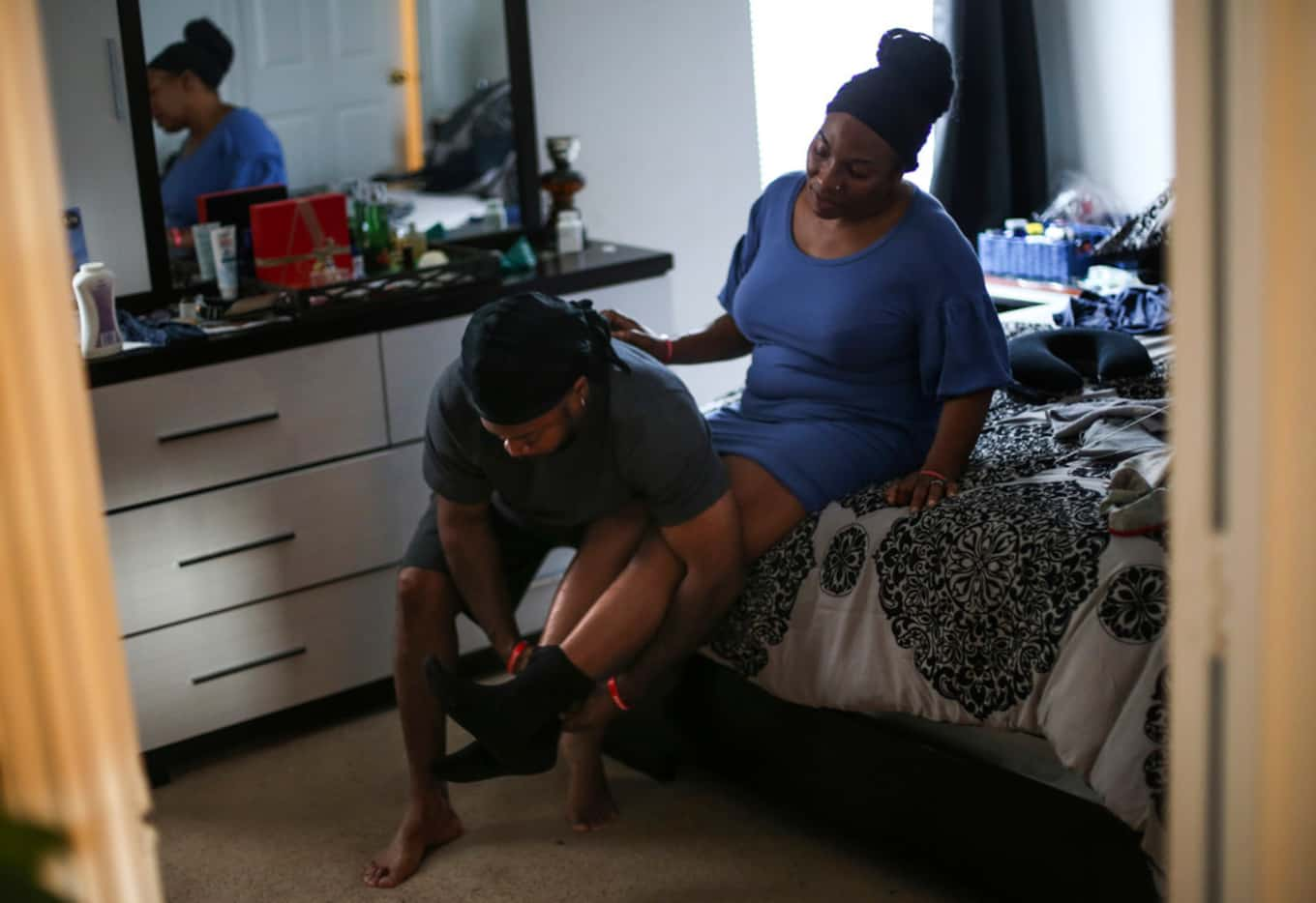 Terrence Barber helps wife Samantha get ready to leave for a worship service. 