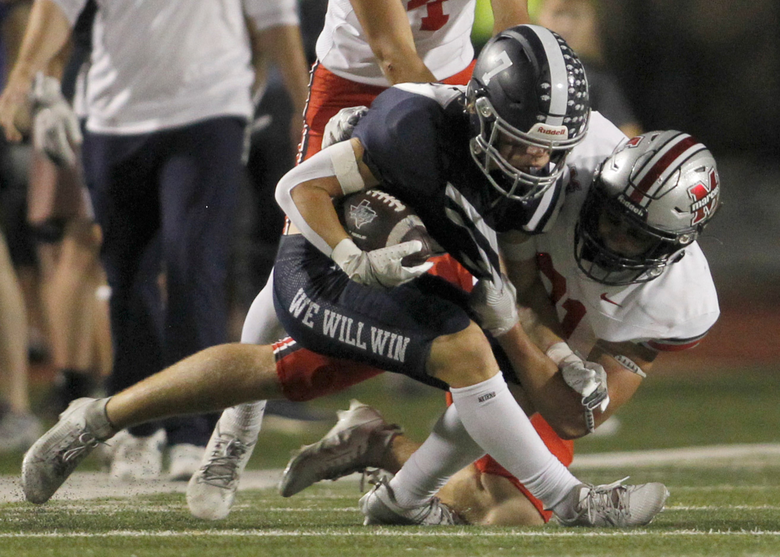 Flower Mound receiver Ryan Stadler (7), center, is tackled by Flower Mound Marcus linebacker...