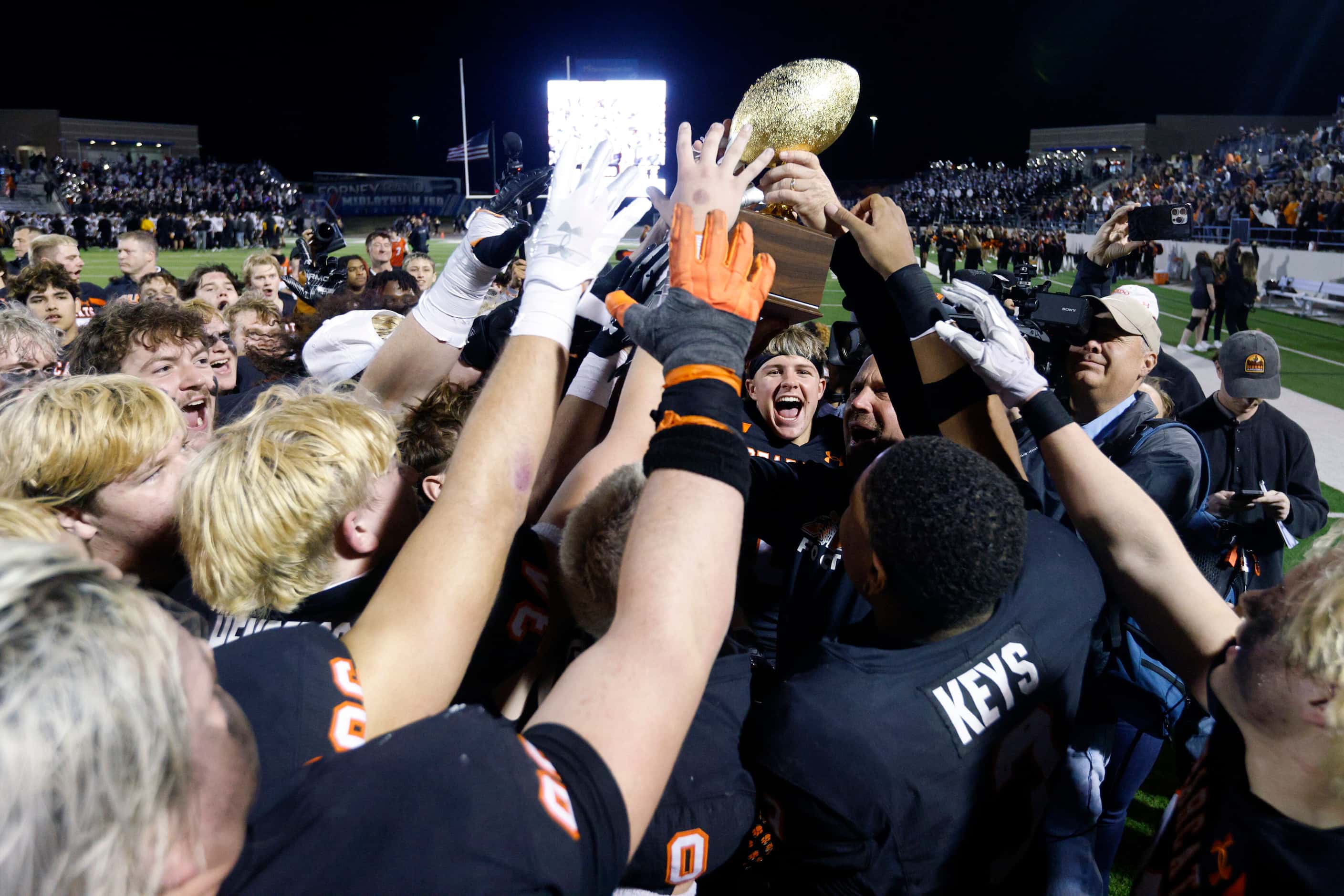 Aledo players raise the state semifinal championship trophy after defeating Forney, Friday,...