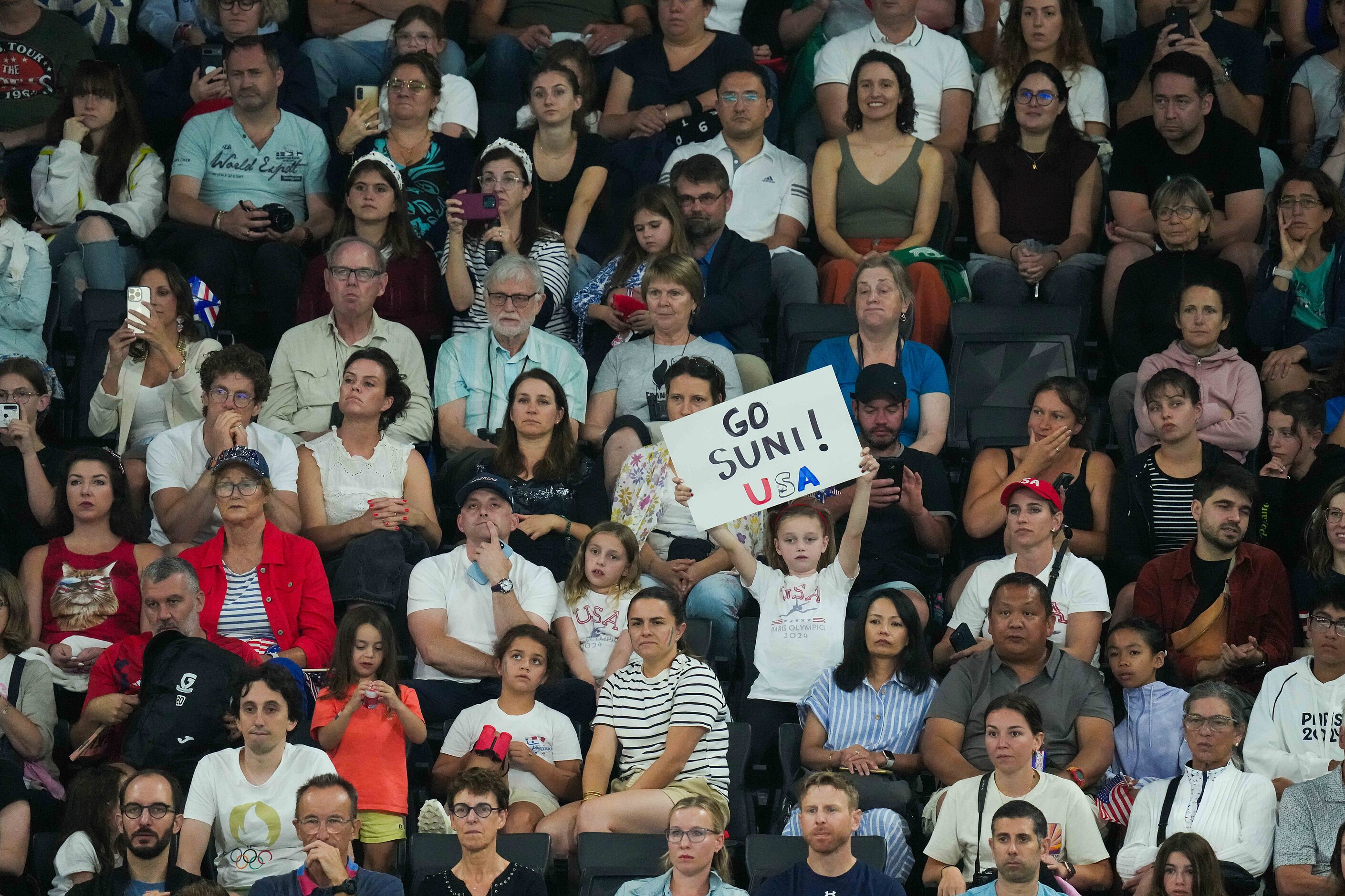 A spectator holds a sign in support of Suni Lee of the United States as she competes on the...