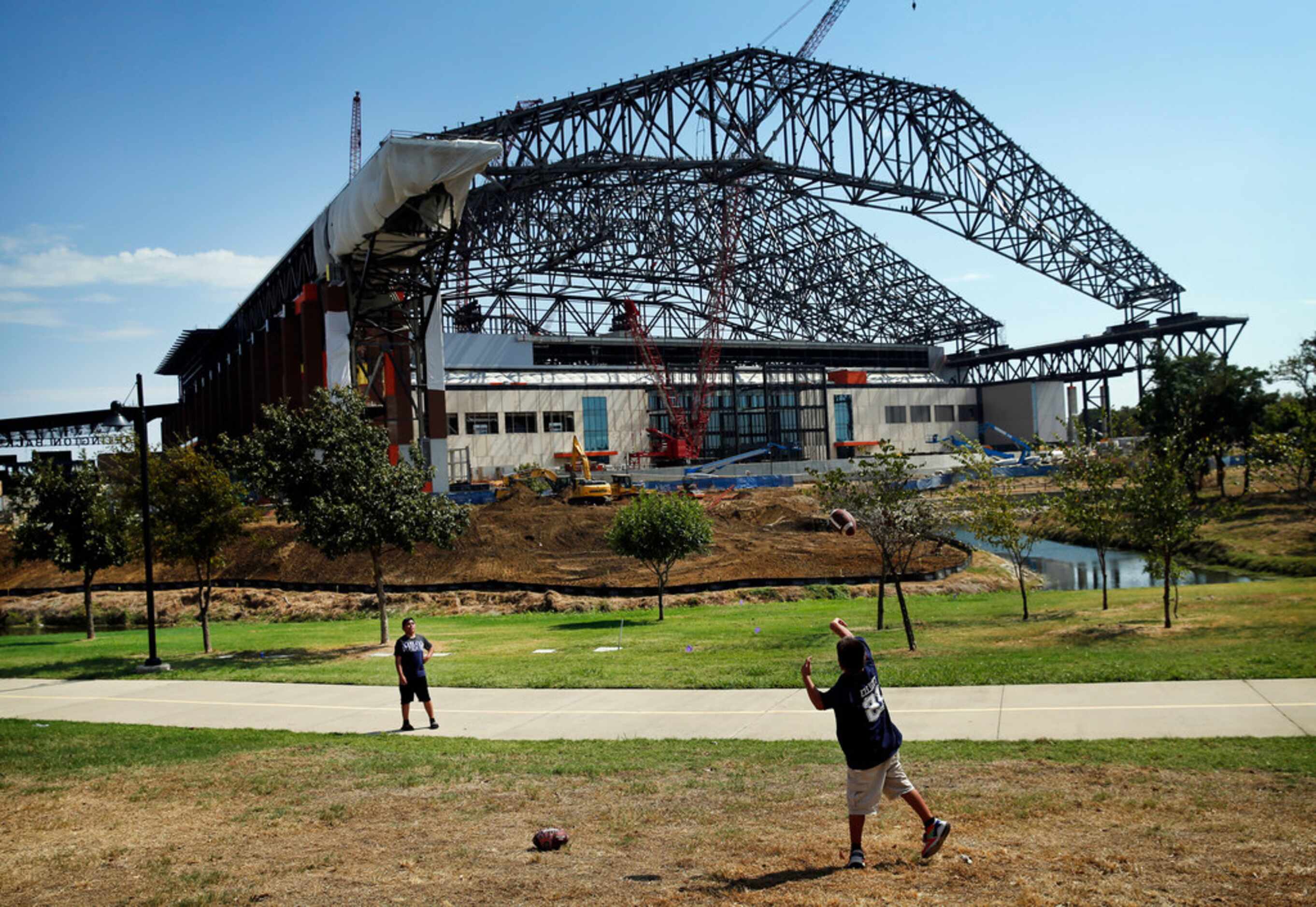 Young Dallas Cowboys fans toss a football before the new Globe Life Field under construction...
