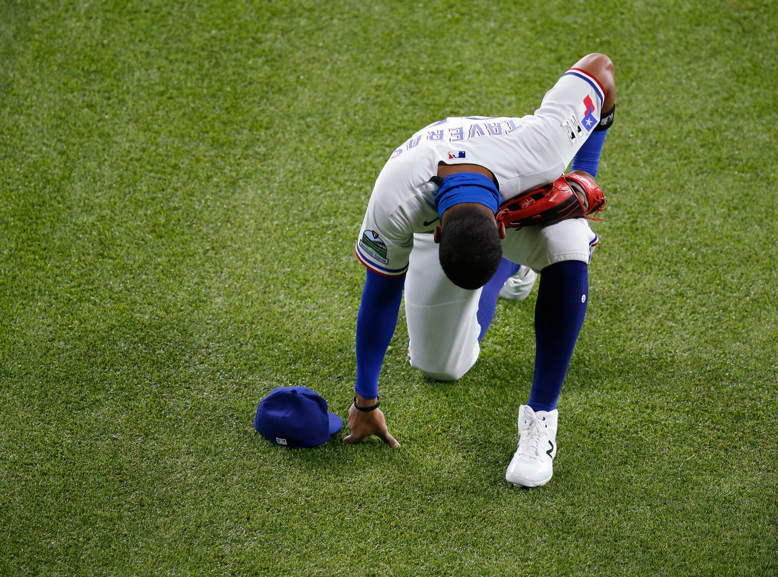 Texas Rangers Leody Taveras (65) takes a knee as he takes the field at the start of the...