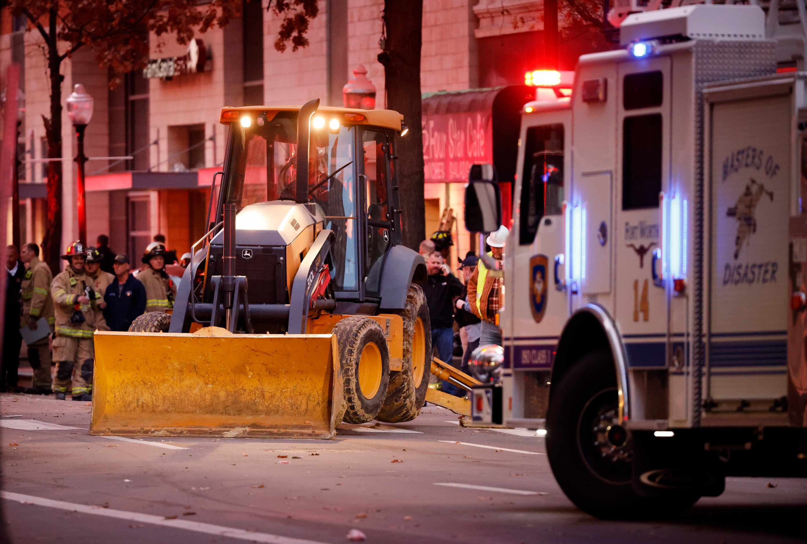 A back hoe goes to work on Houston St following an explosion that occurred at the Sandman...