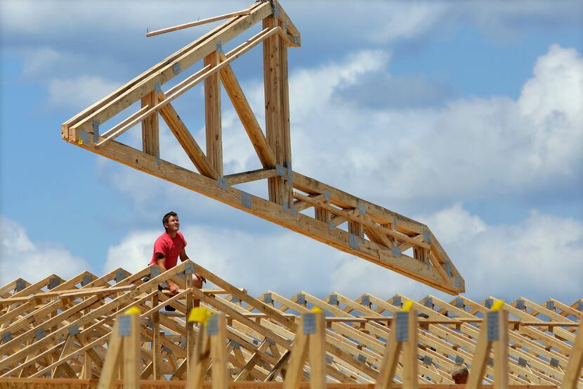 In this July 17, 2014 photo, construction workers build a commercial complex in Springfield,...