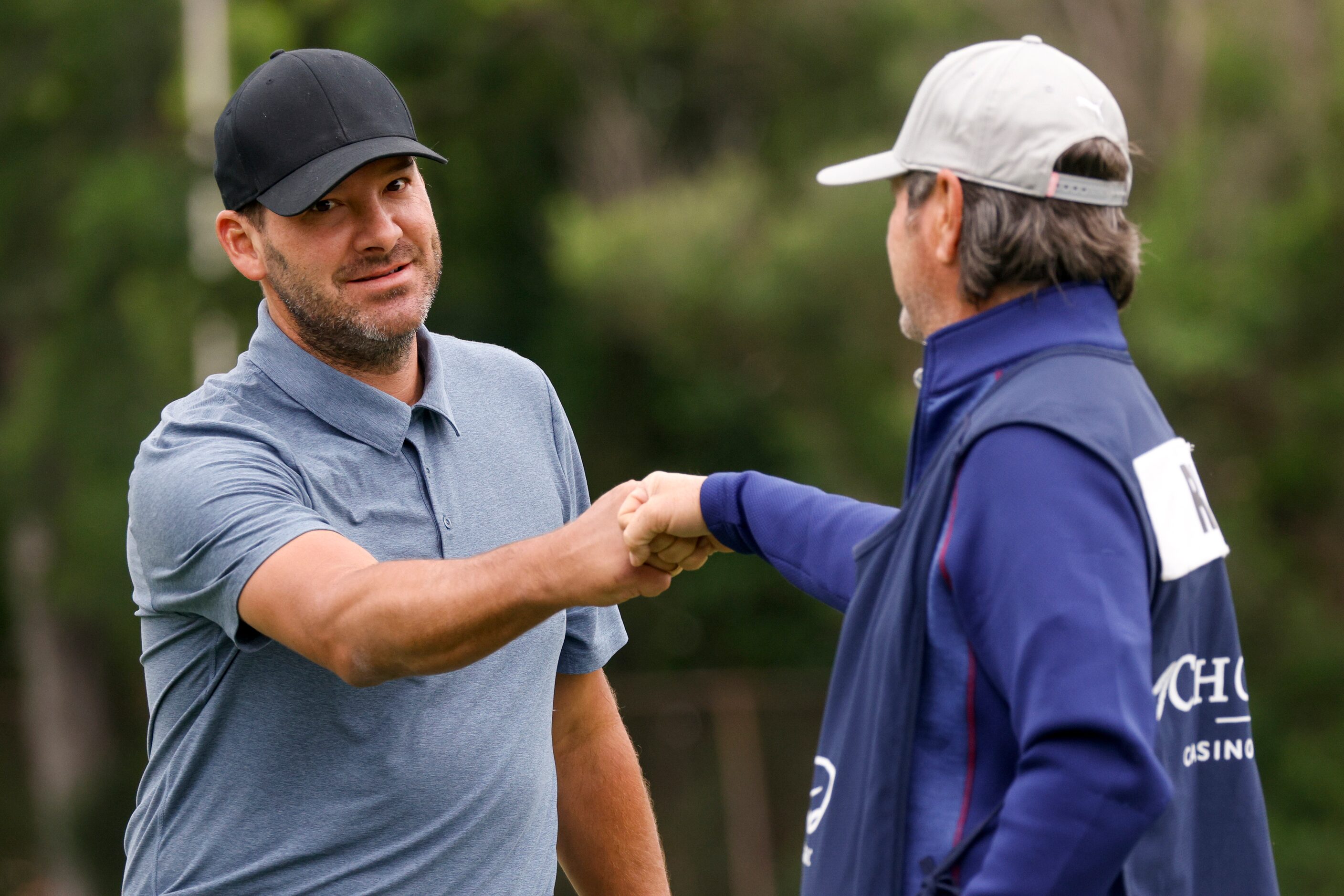 Fformer Dallas Cowboys quarterback Tony Romo fist bumps his caddie after a putt. during the...