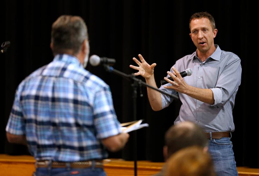 Patrick Moran (right) takes questions from Don Anderson at a community meeting about Moran's...
