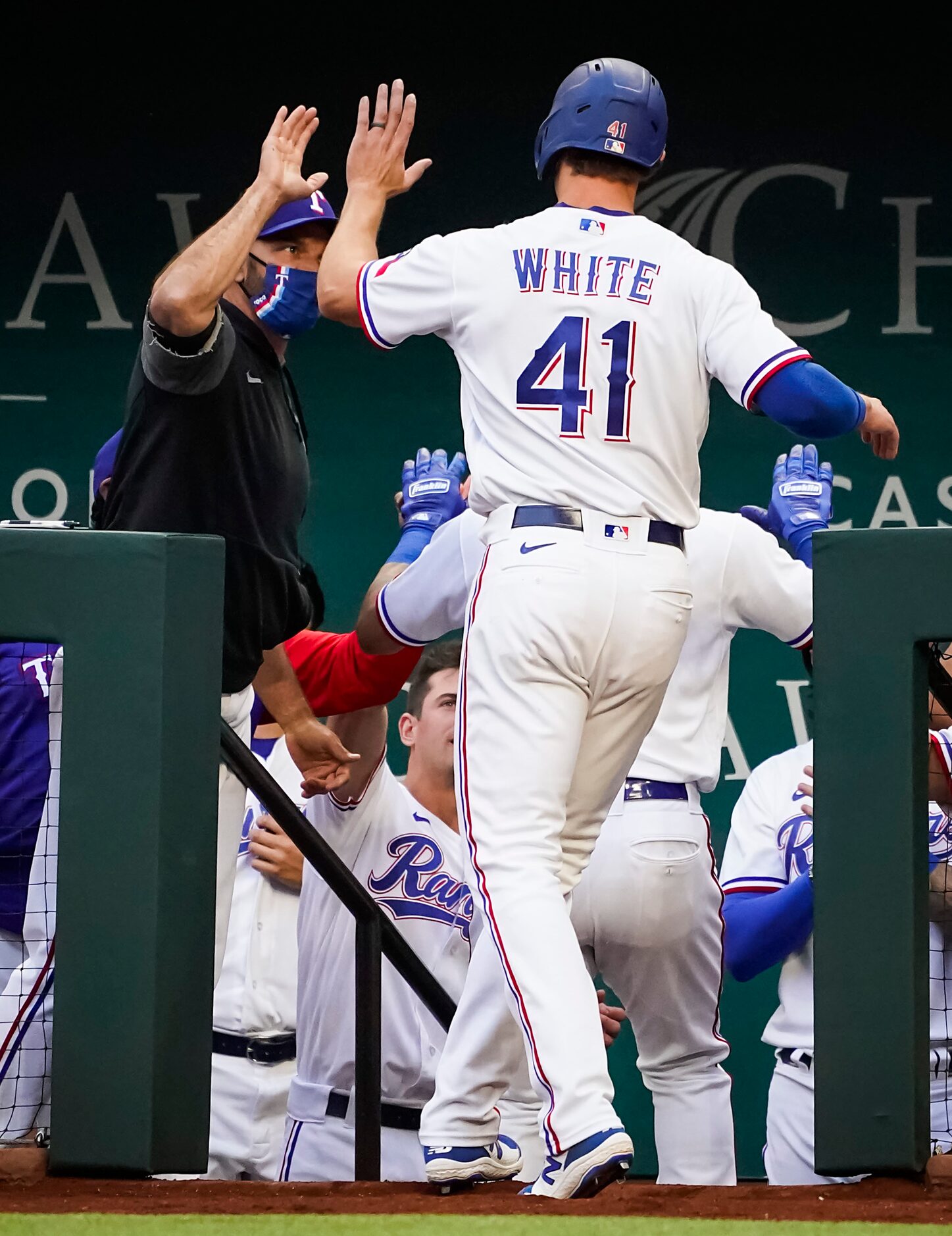 Texas Rangers outfielder Eli White (41) celebrates with manager Chris Woodward after scoring...