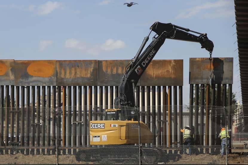 Workers in El Paso replace a section of the border fence next to the international border...