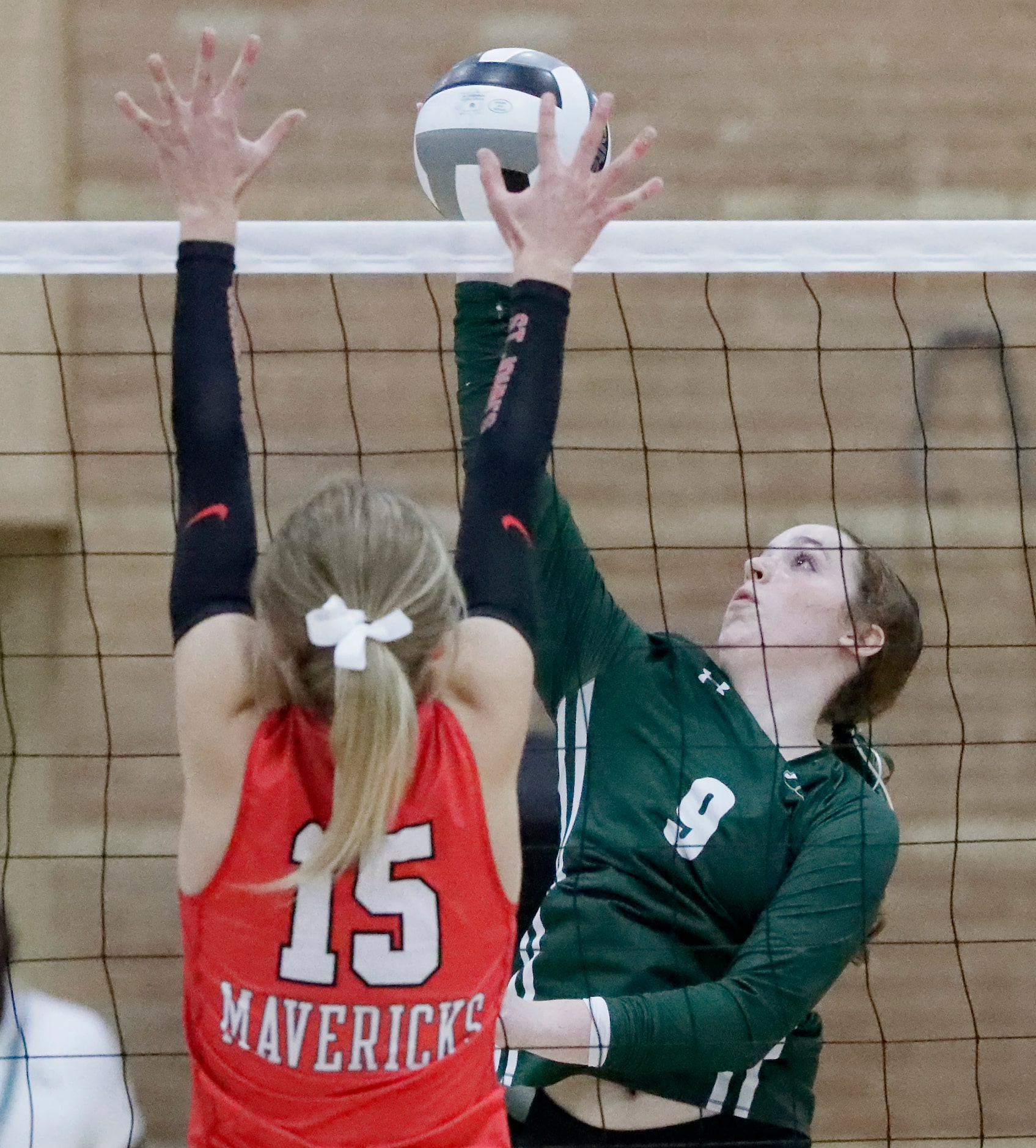 Hockaday outside hitter Mila Haffar (9) gets a hit by St. John’s Olivia Landahl (15) during...