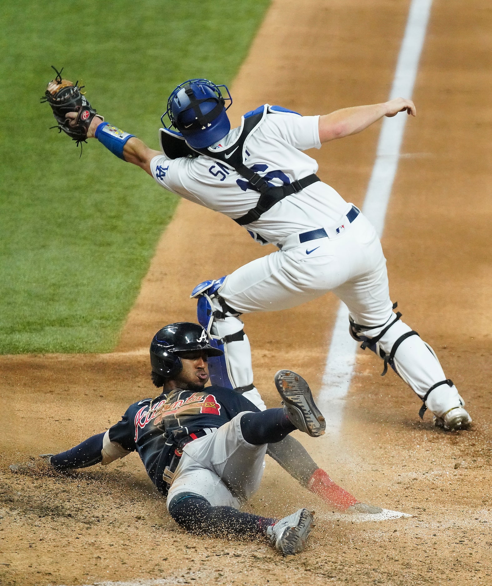 Atlanta Braves second baseman Ozzie Albies (1) scores past Los Angeles Dodgers catcher Will...