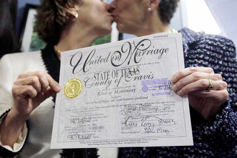 
Suzanne Bryant (left) and Sarah Goodfriend exchanged a kiss while displaying their marriage...