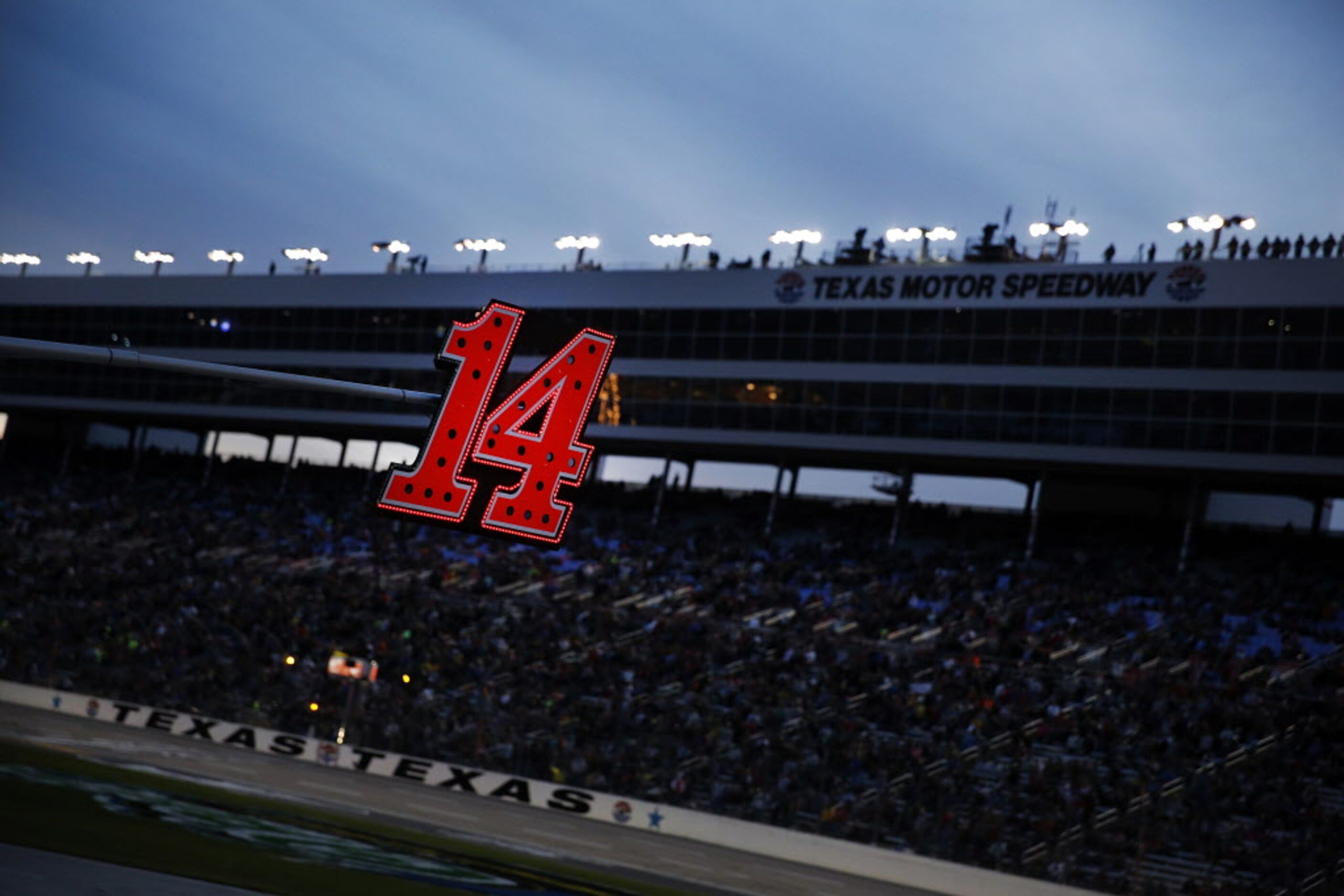 The illuminated flag pole for Sprint Cup Series driver Tony Stewart (14) hangs over the pit...