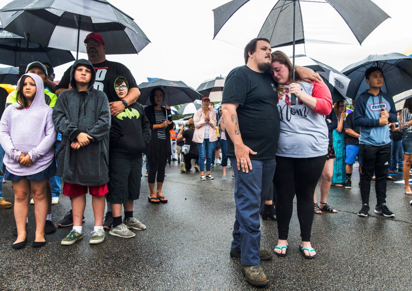 Anthony Moore, center, and his fiancÃ©e Kaitlyn Mitchell, comfort each other during the...