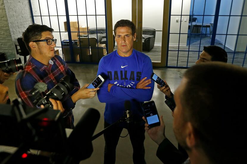 Dallas Mavericks owner Mark Cuban (center) talks with the  media in an interview during the...
