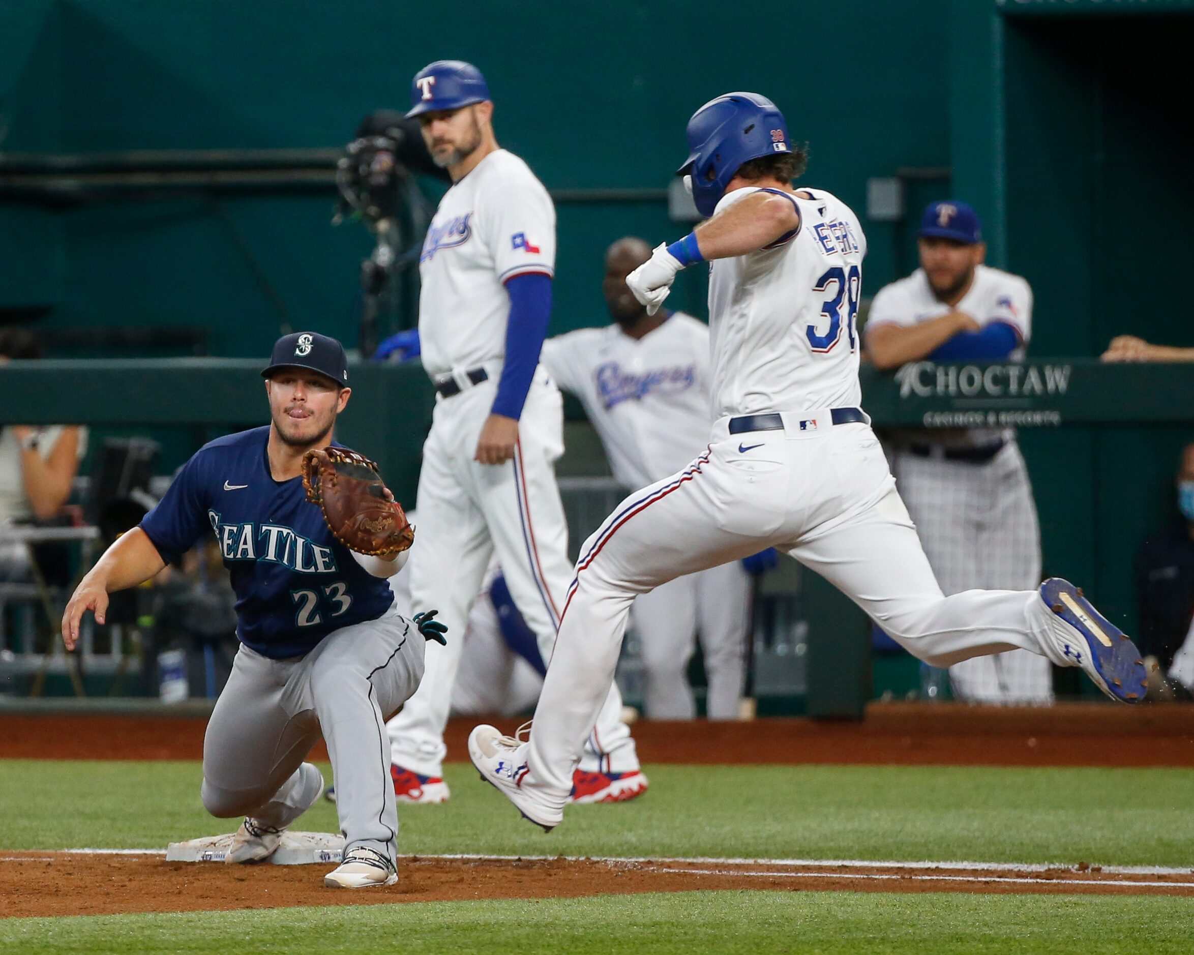 Seattle Mariners first baseman Ty France (23) catches the ball for an out ahead of Texas...