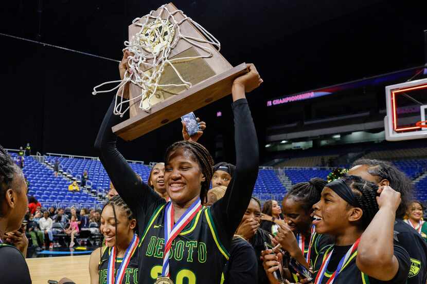 DeSoto guard Ayanna Thompson (20) raises the Class 6A state championship trophy with her...