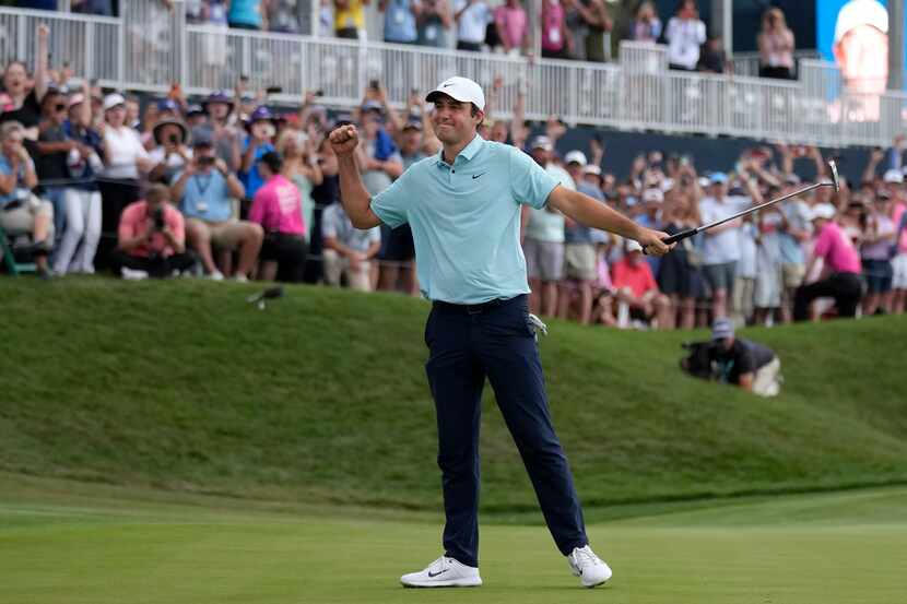 Scottie Scheffler celebrates after putting on the 18th green during the final round of The...
