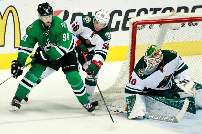 Dallas Stars center Jason Spezza (90) looks to pass as he is covered by Minnesota Wild left...