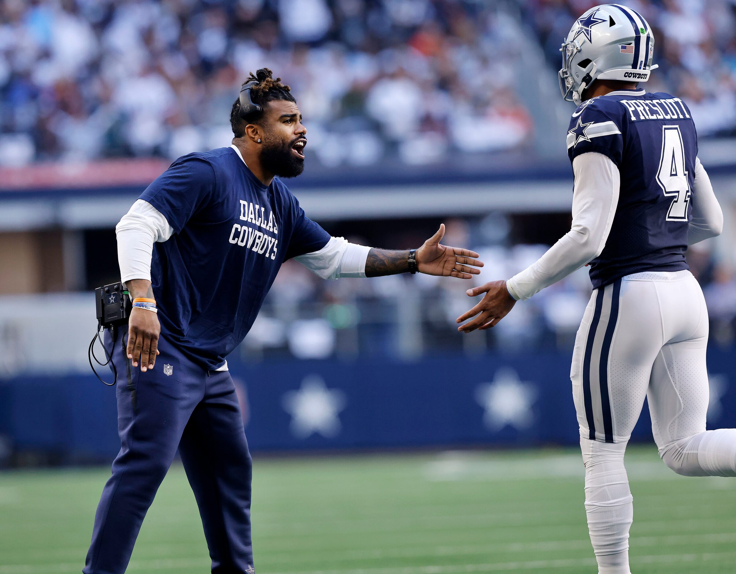 Injured Dallas Cowboys running back Ezekiel Elliott (left) congratulates quarterback Dak...