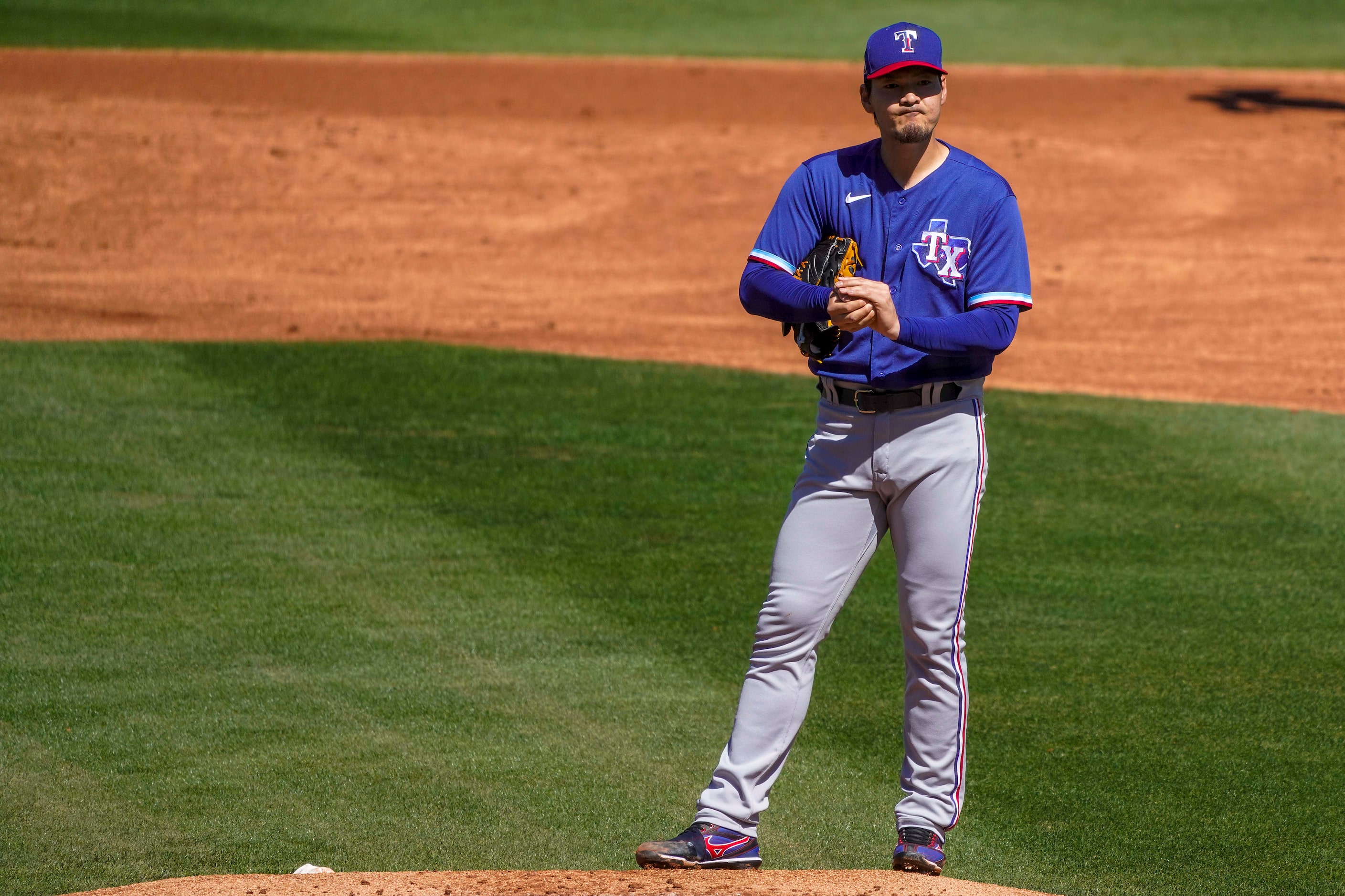 Texas Rangers pitcher Kohei Arihara reacts after a fielding error by shortstop Charlie...