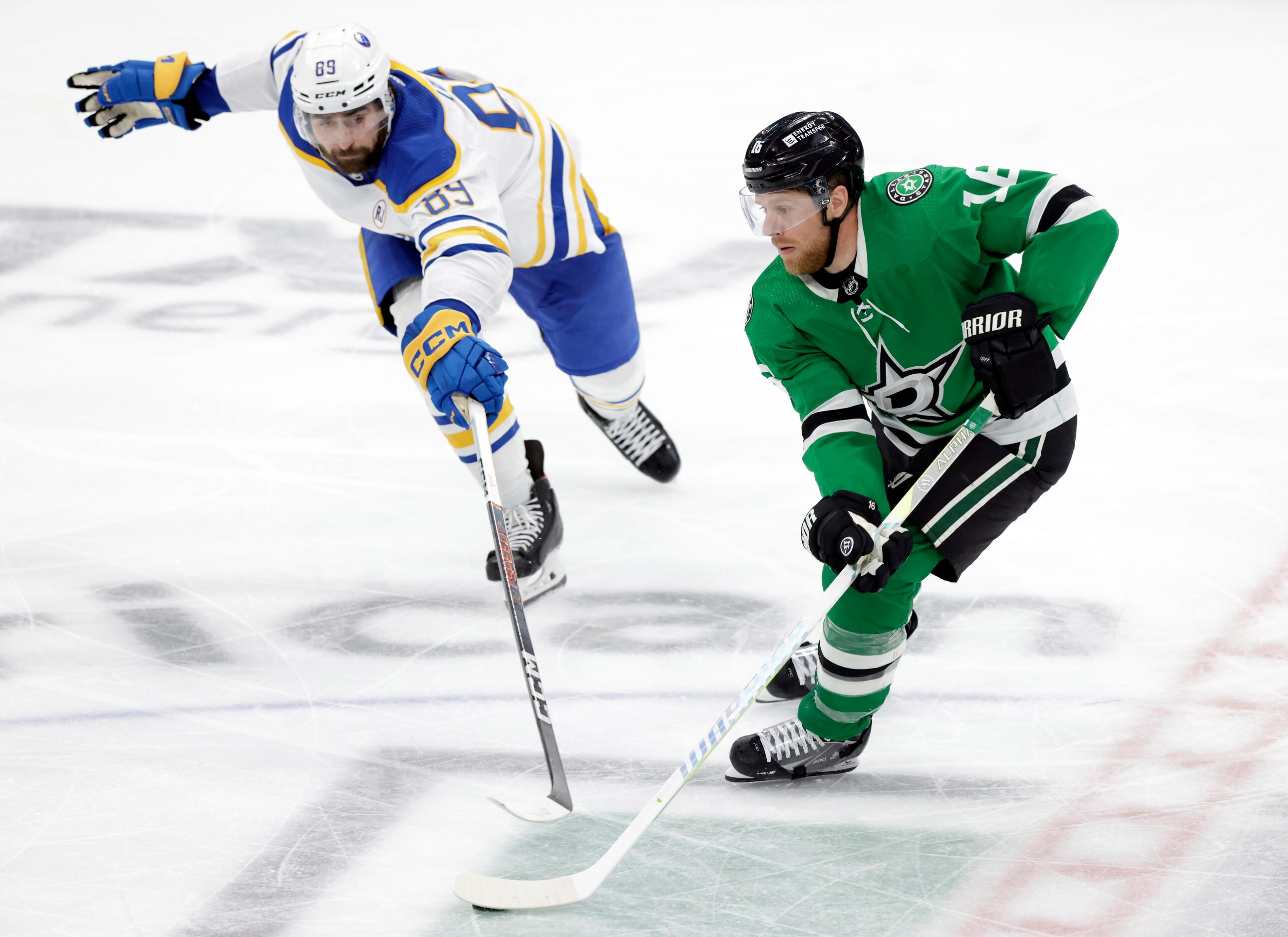 Dallas Stars center Joe Pavelski (16) brings the puck up ice as he is defended by Buffalo...