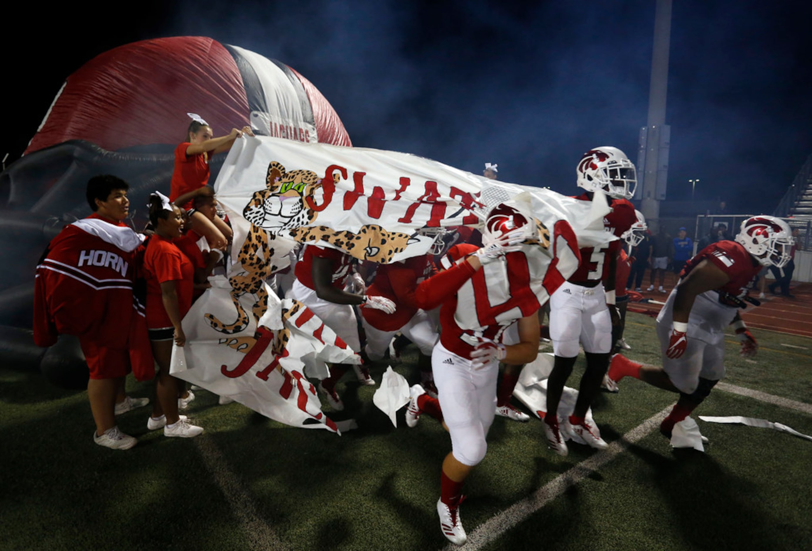 Mesquite Horn players get tangled up in butcher paper, as they run on to the field before...