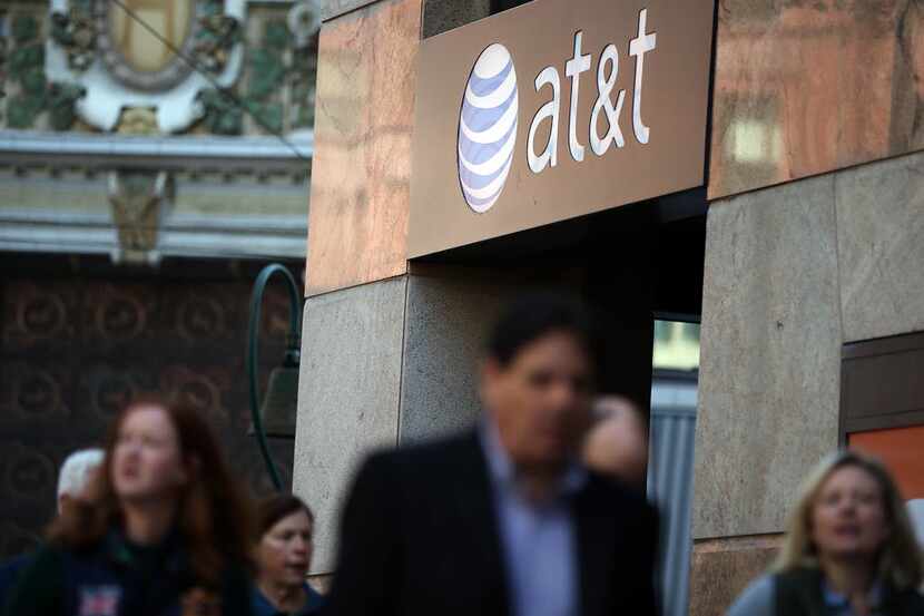 Pedestrians walk by an AT&T store on October 23, 2013 in San Francisco, California.
