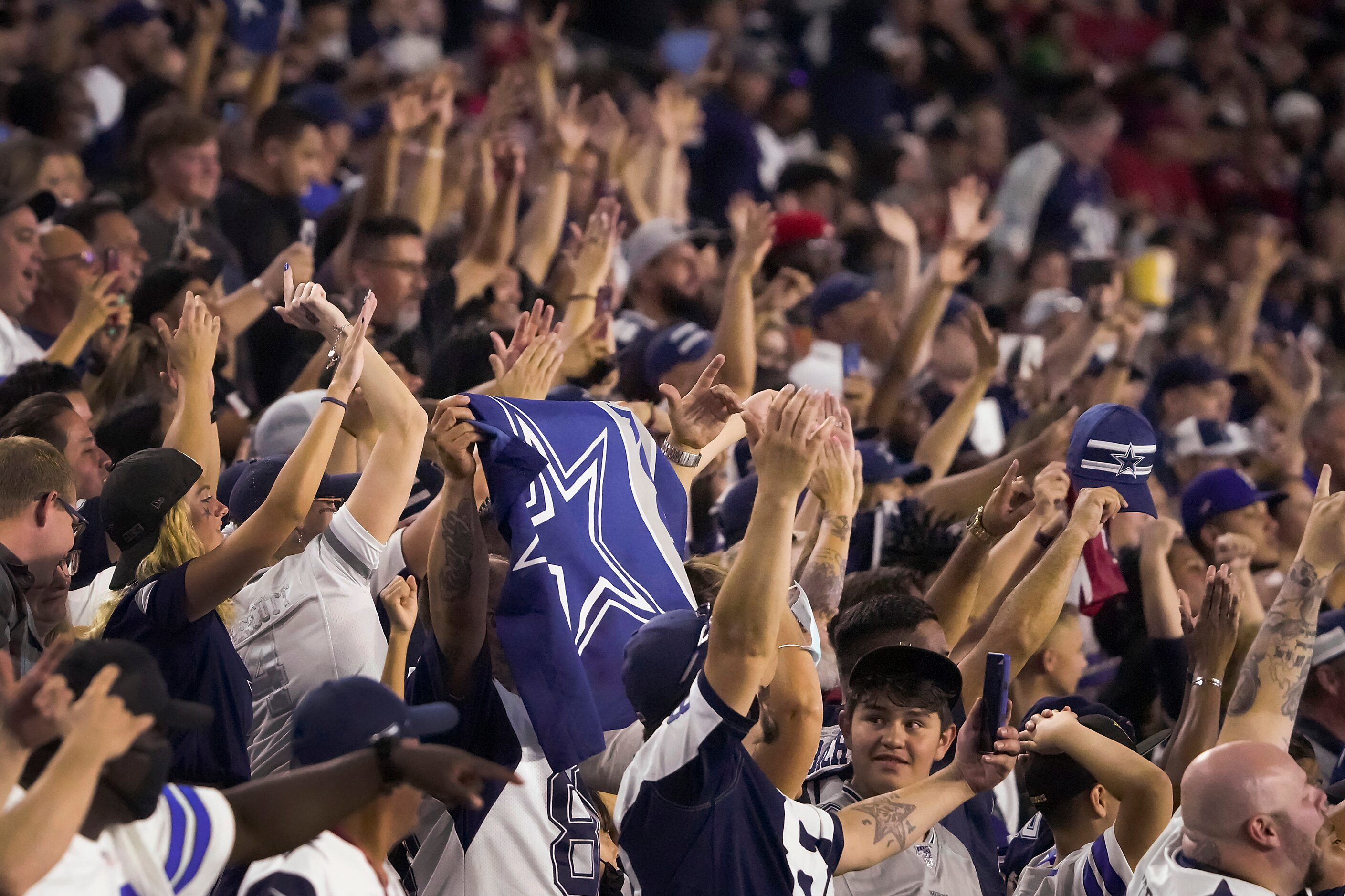 Dallas Cowboys fans cheer their team during the second half of a preseason NFL football game...