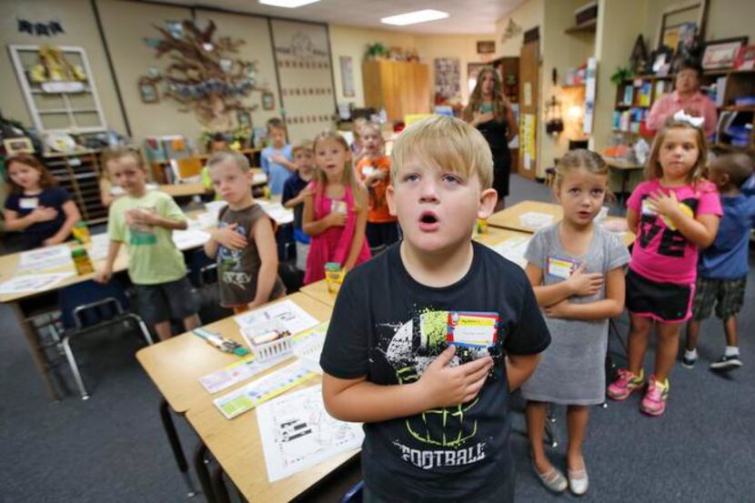 
First-graders recite the Pledge of Allegiance on the first day of school for Yukon Public...