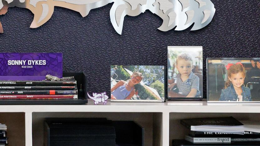 Pictures of TCU head coach Sonny Dykes’ children sit behind the desk in his office at Amon...