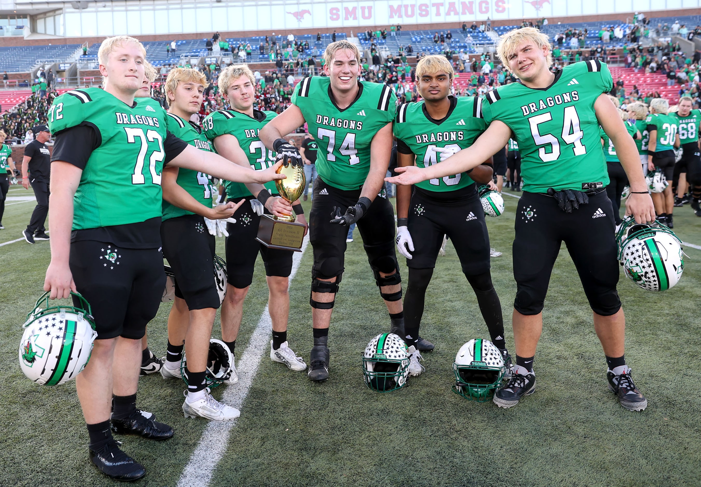 The Southlake Carroll players show off their trophy after defeating Longview, 20-17 in a...