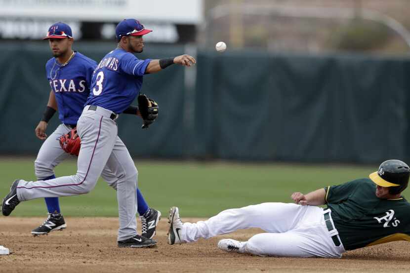 Texas Rangers shortstop Luis Sardinas, center, throws to first to complete a double play as...