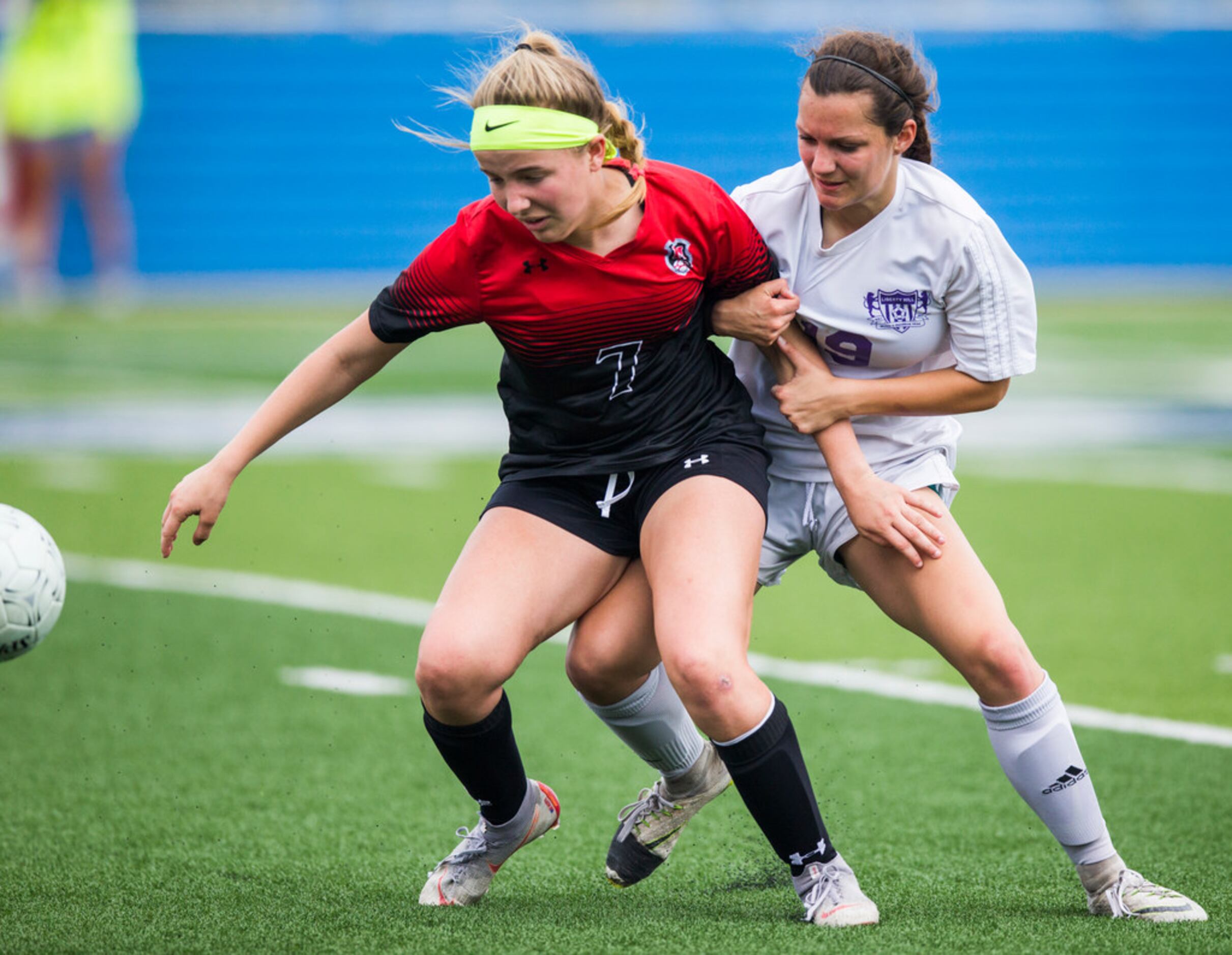 Melissa forward Lucy Hurst (7) is held back by Liberty Hill defender Bryden Bourgeois (19)...