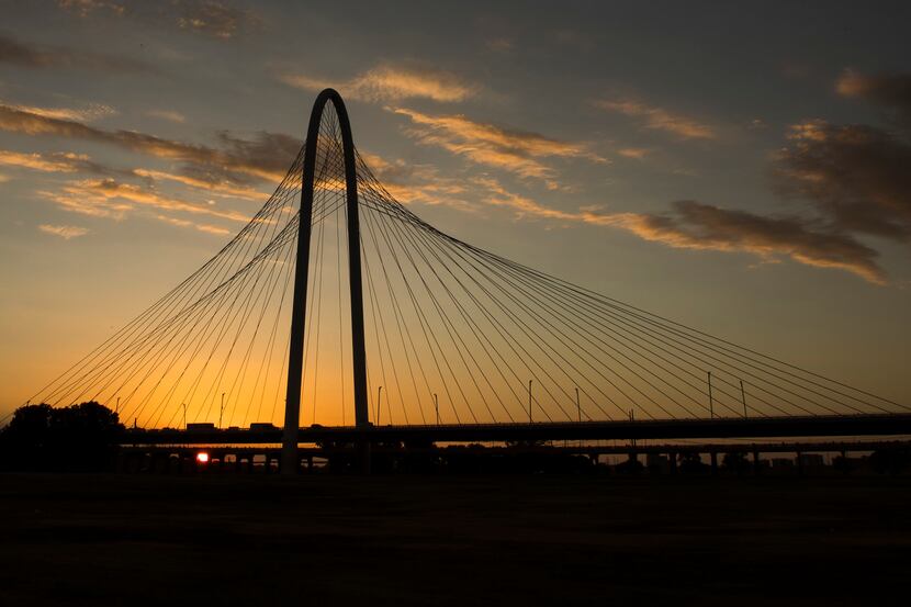 The sun sets behind the Margaret Hunt Hill Bridge on Tuesday, July 3, 2018, in Dallas. 