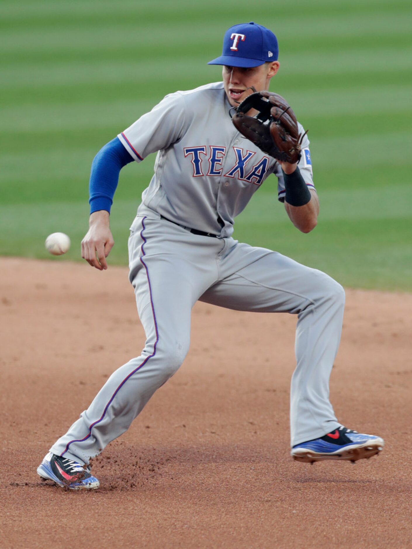 Texas Rangers' Drew Robinson fields a ball hit by Cleveland Indians' Bradley Zimmer in the...