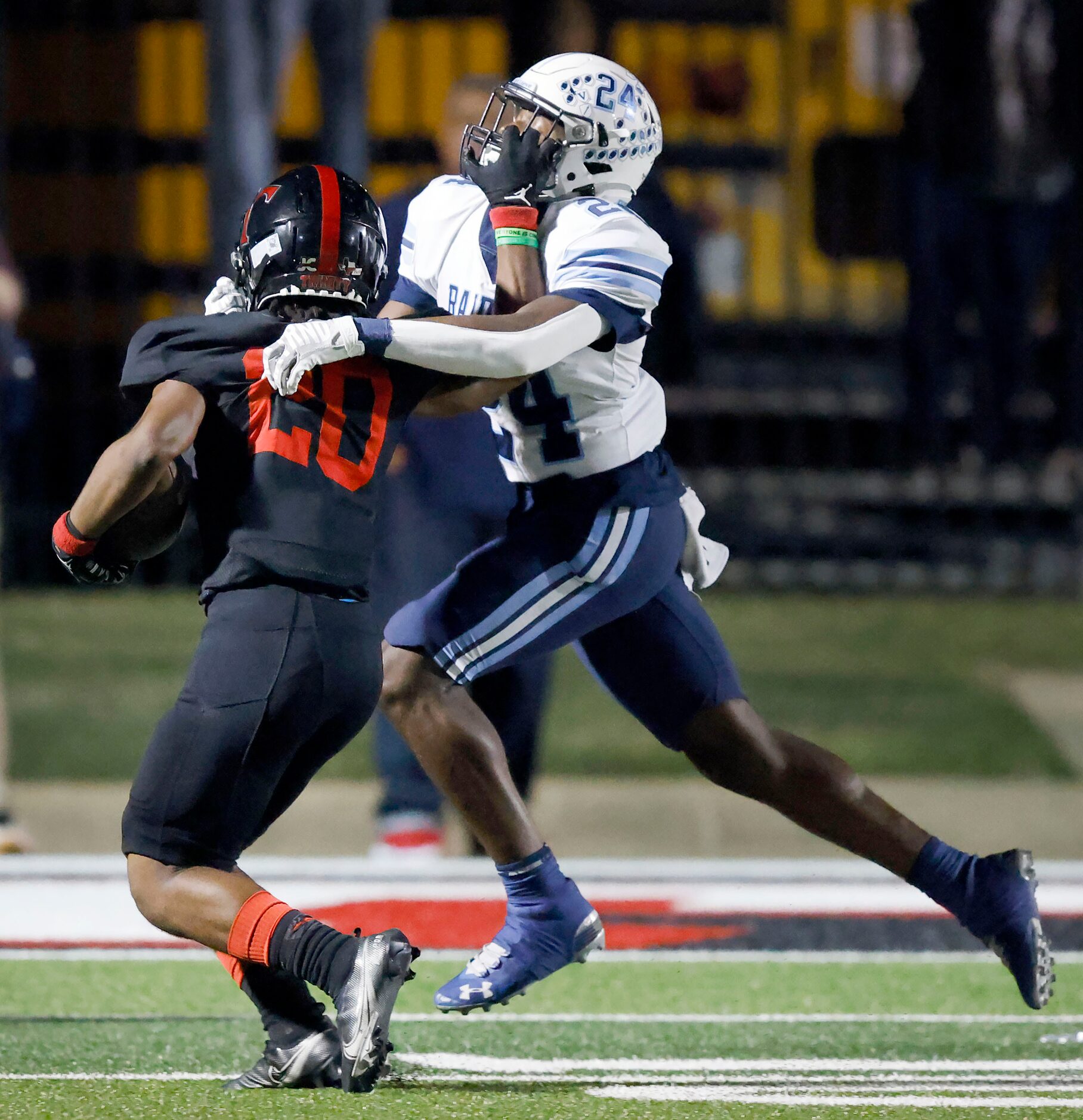 Euless Trinity running back Josh Bell (20) stiff arms Hurst L.D. Bell defensive back...