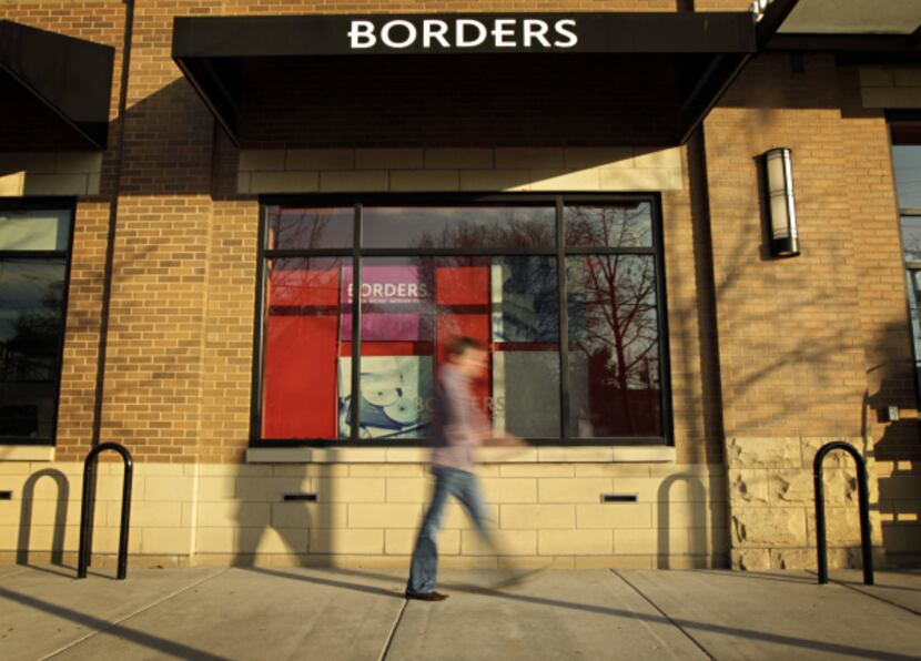 A passerby walks in front of the West Village Borders in Dallas.