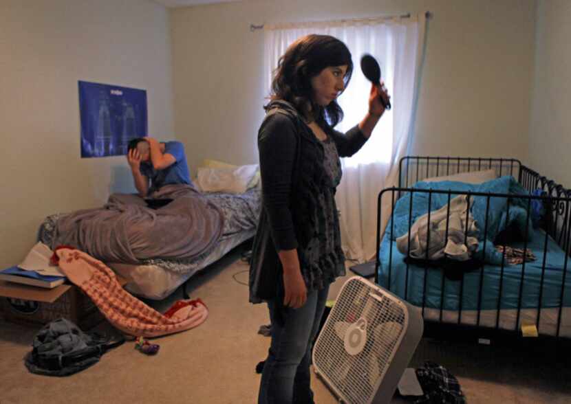 Elise Jones (right) gets ready for the day in her room at the Goodman House in Plano as...