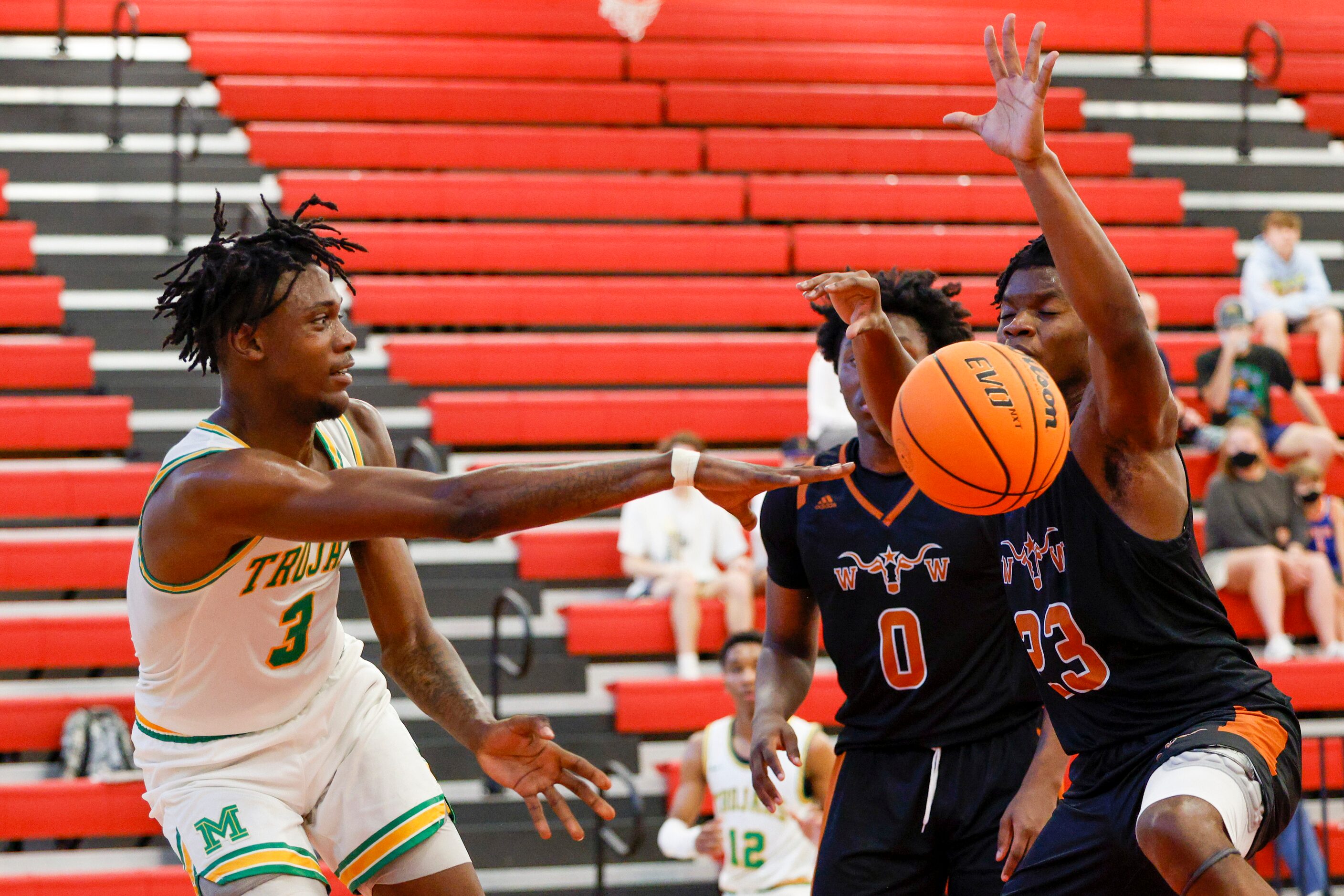 Madison forward Leonard Miles IV (3) passes the ball around W.T. White forwards Dre Cole (0)...