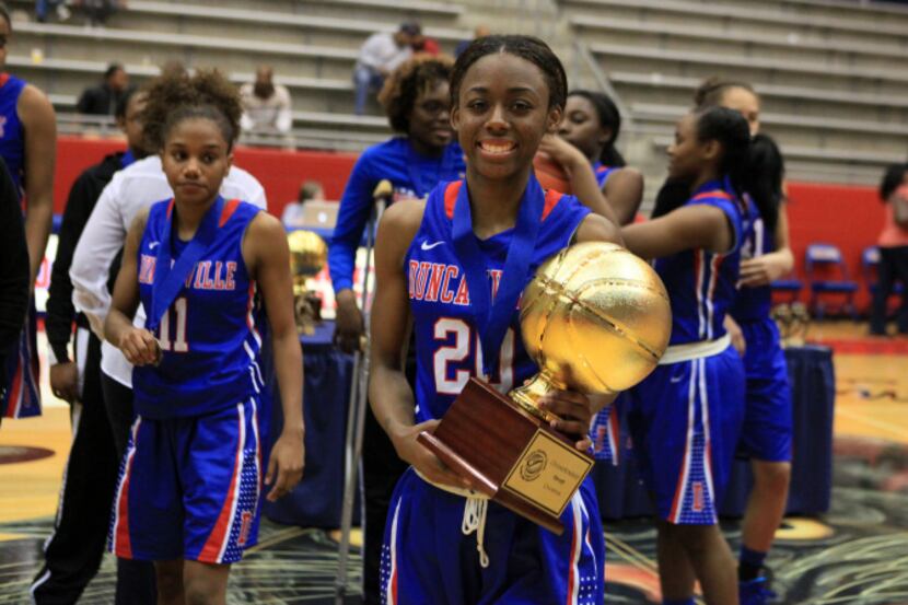 Duncanville senior guard Tasia Foman (20) carries the trophy after defeating Whitney Young...
