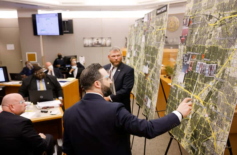 Prosecutor Dimitri Anagnostis (center) points to locations on a large map where FBI special...