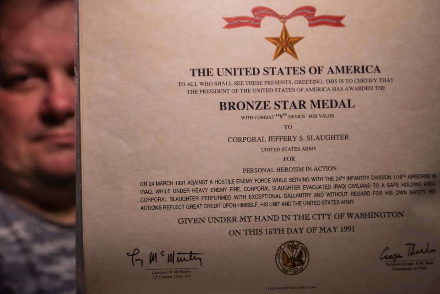 Jeff Slaughter displays the certificate for the Bronze Star awarded for his actions during...