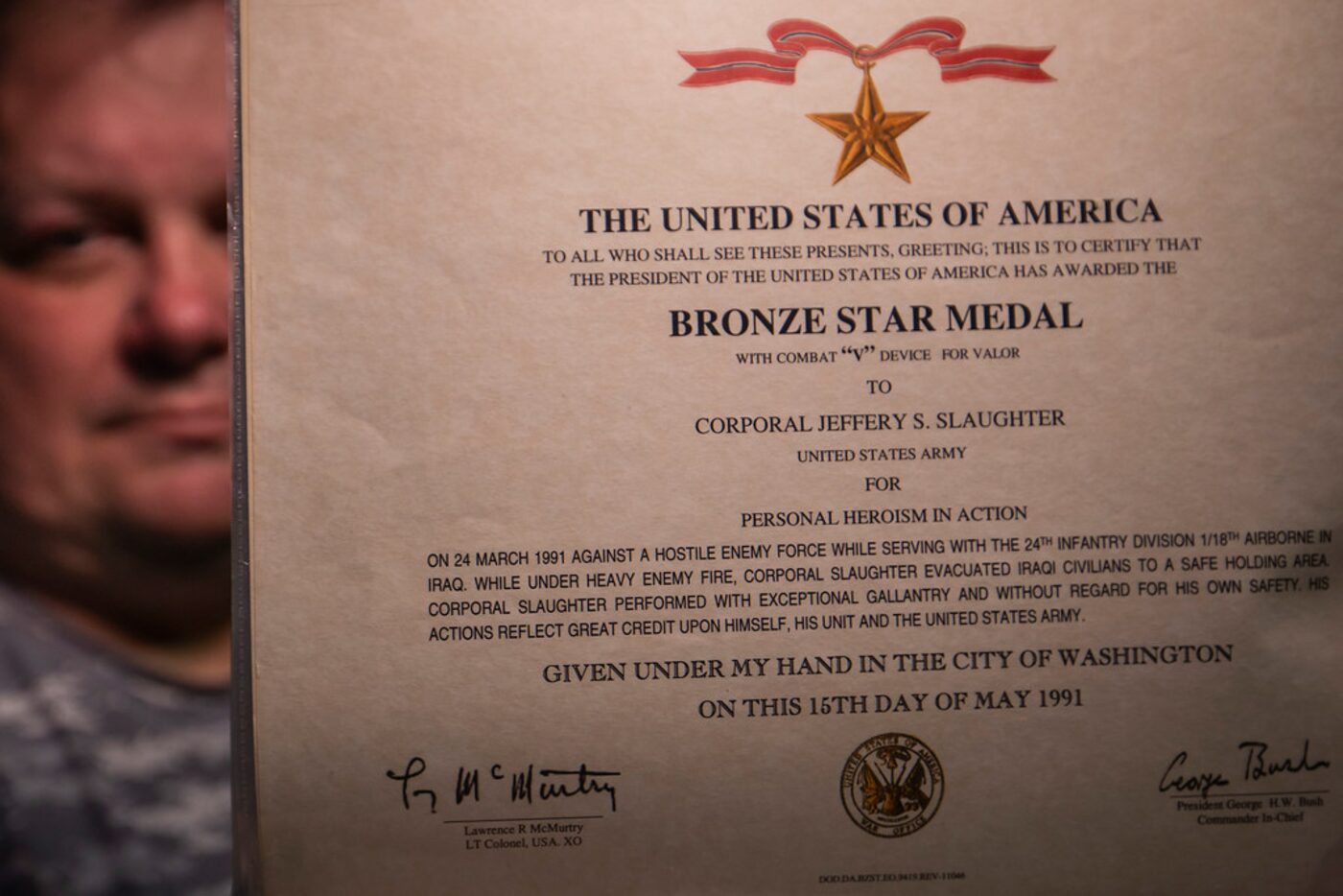 Jeff Slaughter displays the certificate for the Bronze Star awarded for his actions during...